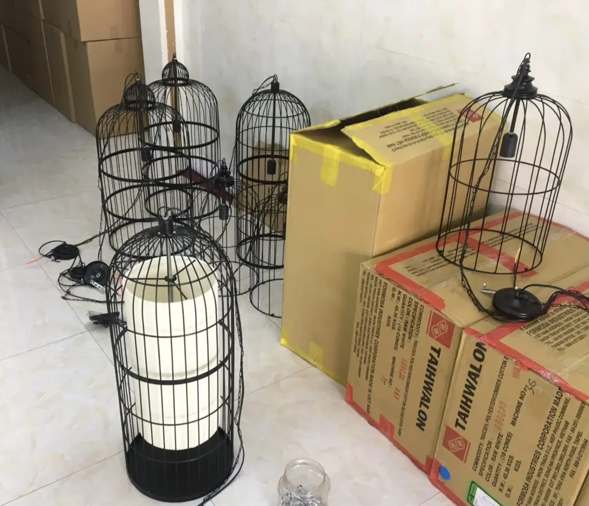 Khung sắt kiểu lồng chưa bọc vải xếp cạnh thùng hàng tại xưởng
